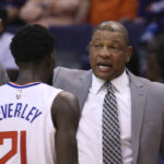 LA Clippers head coach Doc Rivers, right, talks with Clippers guard Patrick Beverley (21) during the first half of a basketball game against the Phoenix Suns Saturday, Oct. 26, 2019, in Phoenix. The Suns defeated the Clippers 130-122. (AP Photo/Ross D. Franklin)