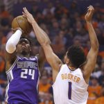 Sacramento Kings guard Buddy Hield shoots over Phoenix Suns guard Devin Booker (1) during the first half of an NBA basketball game Wednesday, Oct. 23, 2019, in Phoenix. (AP Photo/Rick Scuteri)