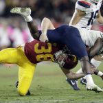 Arizona running back J.J. Taylor, top, is tackled by Southern California place kicker Alex Stadthaus during the second half of an NCAA college football game Saturday, Oct. 19, 2019, in Los Angeles. (AP Photo/Marcio Jose Sanchez)