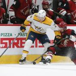 Nashville Predators left wing Daniel Carr (26) and Arizona Coyotes right wing Conor Garland (83) compete for the puck during the third period of an NHL hockey game Thursday, Oct. 17, 2019, in Glendale, Ariz. (AP Photo/Rick Scuteri)