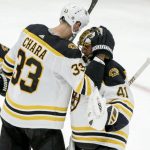 Boston Bruins' Jaroslav Halak (41) gets a hug from his team captain Zdeno Chara (33) after he shut out the Arizona Coyotes 1-0 during an NHL hockey game Saturday, Oct. 5, 2019, in Glendale, Ariz. (AP Photo/Darryl Webb)