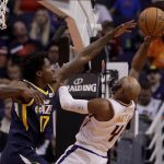 Phoenix Suns guard Jevon Carter (4) shoots over Utah Jazz center Ed Davis (17) during the first half of an NBA basketball game, Monday, Oct. 28, 2019, in Phoenix. (AP Photo/Matt York)