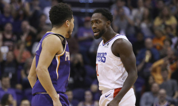 LA Clippers guard Patrick Beverley jaws with Phoenix Suns guard Devin Booker, left, after a Booker ...