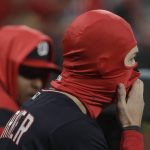 Washington Nationals' Trea Turner puts on a facemark to keep warm during the seventh inning of Game 1 of the baseball National League Championship Series against the St. Louis Cardinals Friday, Oct. 11, 2019, in St. Louis. (AP Photo/Mark Humphrey)