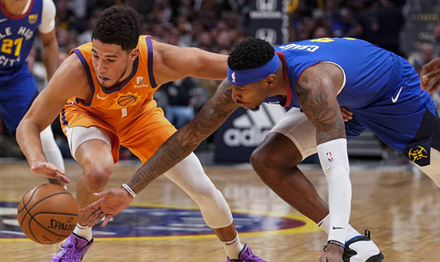 Phoenix Suns guard Devin Booker (1) and Denver Nuggets forward Torrey Craig (3) reach for the ball ...