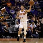 Phoenix Suns guard Devin Booker (1) passes as Denver Nuggets forward Torrey Craig defends during the second half of an NBA preseason basketball game, Monday, Oct. 14, 2019, in Phoenix. (AP Photo/Matt York)