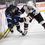 Winnipeg Jets' Neal Pionk (4) and Arizona Coyotes' Clayton Keller (9) chase the puck along the boards during the second period of an NHL hockey game Tuesday, Oct. 15, 2019, in Winnipeg, Manitoba. (Fred Greenslade/The Canadian Press via AP)