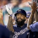 Milwaukee Brewers' Eric Thames high fives teammates after hitting a solo home run during the second inning of a National League wild card baseball game against the Washington Nationals at Nationals Park, Tuesday, Oct. 1, 2019, in Washington. (AP Photo/Andrew Harnik)