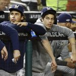Milwaukee Brewers' Christian Yelich, third from left, sits in the dugout in the fifth inning of a National League wild card baseball game against the Washington Nationals, Tuesday, Oct. 1, 2019, in Washington. (AP Photo/Patrick Semansky)