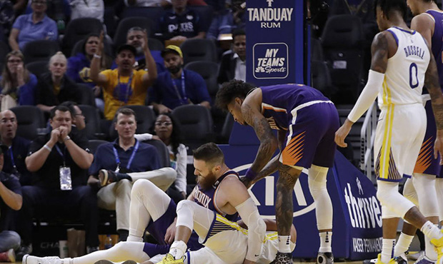 Phoenix Suns' Aron Baynes, left, gets up after falling onto Golden State Warriors' Stephen Curry du...