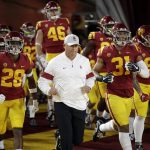 Southern California coach Clay Helton runs onto the field with this team for the start of an NCAA college football game against Arizona on Saturday, Oct. 19, 2019, in Los Angeles. (AP Photo/Marcio Jose Sanchez)