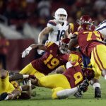 Arizona quarterback Grant Gunnell (17) is tackled by a group of Southern California defenders during the second half of an NCAA college football game Saturday, Oct. 19, 2019, in Los Angeles. (AP Photo/Marcio Jose Sanchez)