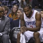 LA Clippers forward Kawhi Leonard, right, sits on the bench with assistant coach Sam Cassell, left, during the closing moments second half of a basketball game loss against the Phoenix Suns Saturday, Oct. 26, 2019, in Phoenix. The Suns defeated the Clippers 130-122. (AP Photo/Ross D. Franklin)