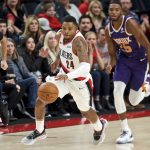 Portland Trail Blazers guard Kent Bazemore (24) dribbles the ball in front of Phoenix Suns forward Mikal Bridges (25) during the first half of a preseason NBA basketball game in Portland, Ore., Saturday, Oct. 12, 2019. (AP Photo/Craig Mitchelldyer)