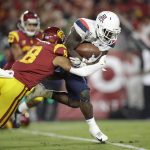 Arizona running back J.J. Taylor, right, is tackled by Southern California cornerback Chris Steele (8) during the first half of an NCAA college football game Saturday, Oct. 19, 2019, in Los Angeles. (AP Photo/Marcio Jose Sanchez)