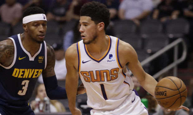 Phoenix Suns guard Devin Booker (1) moves the ball upcourt as Denver Nuggets forward Torrey Craig (...