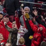 Fans try to catch a foul ball hit by St. Louis Cardinals' Kolten Wong during the first inning of Game 1 of the baseball National League Championship Series against the Washington Nationals Friday, Oct. 11, 2019, in St. Louis. (AP Photo/Charlie Riedel)