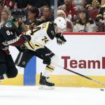Boston Bruins' Jake BeBrusk (74) runs down the puck against the Arizona Coyotes' Jordan Oesterle (82) during the first period of an NHL hockey game Saturday, Oct. 5, 2019, in Glendale, Ariz. (AP Photo/Darryl Webb)