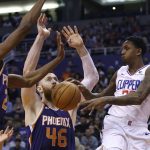 LA Clippers guard Lou Williams, right, passes the ball between Phoenix Suns center Aron Baynes (46) and Suns forward Mikal Bridges, left, during the first half of a basketball game Saturday, Oct. 26, 2019, in Phoenix. (AP Photo/Ross D. Franklin)