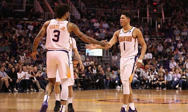 Devin Booker #1 of the Phoenix Suns high fives Kelly Oubre Jr. #3 after scoring against the Milwauk...