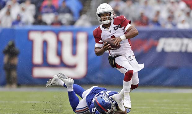 Arizona Cardinals quarterback Kyler Murray, top, evades a tackle by New York Giants' Oshane Ximines...