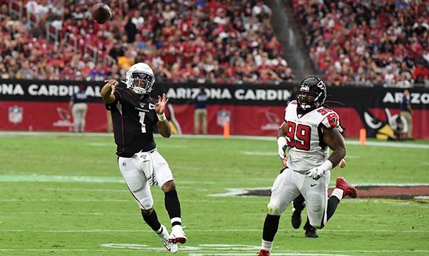 Kyler Murray #1 of the Arizona Cardinals throws the ball down field while being chased by Adrian Cl...