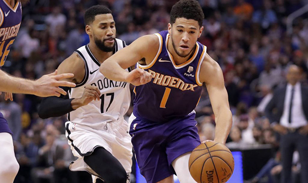 Phoenix Suns guard Devin Booker (1) drives as Brooklyn Nets guard Garrett Temple (17) defends durin...