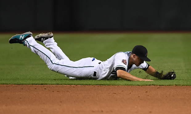 Nick Ahmed #13 of the Arizona Diamondbacks makes a diving stop on a ground ball against the Texas R...