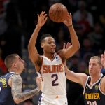 DENVER, COLORADO - NOVEMBER 24: Elie Okobo #2 of the Phoenix Suns outlets the ball while being guarded by Juancho Hernangomez #41 and Mason Plumlee #24 of the Denver Nuggets in the second quarter at the Pepsi Center on November 24, 2019 in Denver, Colorado.  NOTE TO USER: User expressly acknowledges and agrees that, by downloading and or using this photograph, User is consenting to the terms and conditions of the Getty Images License Agreement.  (Photo by Matthew Stockman/Getty Images)