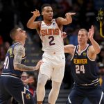 DENVER, COLORADO - NOVEMBER 24: Elie Okobo #2 of the Phoenix Suns outlets the ball while being guarded by Juancho Hernangomez #41 and Mason Plumlee #24 of the Denver Nuggets in the second quarter at the Pepsi Center on November 24, 2019 in Denver, Colorado.  NOTE TO USER: User expressly acknowledges and agrees that, by downloading and or using this photograph, User is consenting to the terms and conditions of the Getty Images License Agreement.  (Photo by Matthew Stockman/Getty Images)