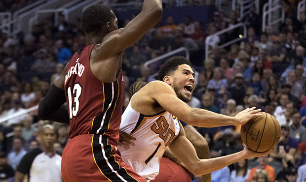Phoenix Suns' Devin Booker (1) drives to the basket against Miami Heat's Bam Adebayo (13) during th...