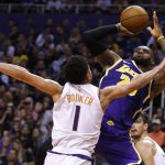 Los Angeles Lakers forward LeBron James gets fouled by Phoenix Suns guard Devin Booker (1) in the first half during an NBA basketball game, Tuesday, Nov. 12, 2019, in Phoenix. (AP Photo/Rick Scuteri)