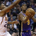 Los Angeles Lakers guard Rajon Rondo (9) drives past Phoenix Suns forward Mikal Bridges in the first half during an NBA basketball game, Tuesday, Nov. 12, 2019, in Phoenix. (AP Photo/Rick Scuteri)