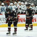Arizona Coyotes center Nick Schmaltz (8) and right wing Conor Garland (83) pause on the ice after a goal scored by San Jose Sharks' Dylan Gambrell during the second period of an NHL hockey game Saturday, Nov. 30, 2019, in Glendale, Ariz. (AP Photo/Ross D. Franklin)