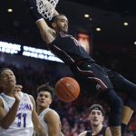 New Mexico State guard Trevelin Queen (21) dunks over Arizona forward Ira Lee (11) in the first half of an NCAA college basketball game, Sunday, Nov. 17, 2019, in Tucson, Ariz. (AP Photo/Rick Scuteri)