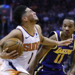 Phoenix Suns guard Devin Booker (1) gets fouled by Los Angeles Lakers guard Avery Bradley in the second half of an NBA basketball game, Tuesday, Nov. 12, 2019, in Phoenix. (AP Photo/Rick Scuteri)