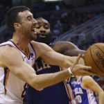 Phoenix Suns forward Frank Kaminsky (8) is fouled as he goes up for a shot against Philadelphia 76ers center Kyle O'Quinn, right, during the second half of an NBA basketball game, Monday, Nov. 4, 2019, in Phoenix. The Suns defeated the 76ers 114-109. (AP Photo/Ross D. Franklin)