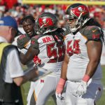 Tampa Bay Buccaneers defensive end Jason Pierre-Paul, let, has to be restrained by defensive tackle Rakeem Nunez-Roches (56) from getting to defensive tackle Vita Vea (50) after an Arizona Cardinals run during the second half of an NFL football game Sunday, Nov. 10, 2019, in Tampa, Fla. (AP Photo/Mark LoMoglio)