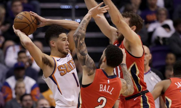Phoenix Suns guard Devin Booker, left, is pressured by New Orleans Pelicans guard Lonzo Ball (2) an...
