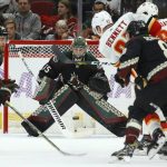 Arizona Coyotes goaltender Darcy Kuemper (35) gets ready to make a save on a shot by Calgary Flames center Sam Bennett (93) as Coyotes defenseman Jordan Oesterle (82) and Coyotes center Nick Schmaltz (8) defend during the second period of an NHL hockey game, Saturday, Nov. 16, 2019, in Glendale, Ariz. (AP Photo/Ross D. Franklin)