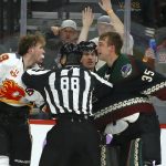 Linesman Tyson Baker (88) tries to break up Calgary Flames left wing Matthew Tkachuk, left, and Arizona Coyotes goaltender Darcy Kuemper (35) during a brawl during the second period of an NHL hockey game, Saturday, Nov. 16, 2019, in Glendale, Ariz. (AP Photo/Ross D. Franklin)
