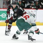 Arizona Coyotes left wing Christian Dvorak (18) carries the puck in front of Minnesota Wild left wing Jason Zucker in the second period during an NHL hockey game, Saturday, Nov. 9, 2019, in Glendale, Ariz. (AP Photo/Rick Scuteri)