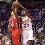 Phoenix Suns forward Mikal Bridges (25) shoots next to New Orleans Pelicans guard Kenrich Williams (34) during the second half of an NBA basketball game Thursday, Nov. 21, 2019, in Phoenix. (AP Photo/Matt York)