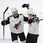 Arizona Coyotes right wing Conor Garland (83) with defenseman Jordan Oesterle (82) celebrates after he scored a goal during a shootout of an NHL hockey game against the Washington Capitals, Monday, Nov. 11, 2019, in Washington. The Coyotes won 4-3 after a shootout. (AP Photo/Nick Wass)