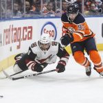 Arizona Coyotes ' Vinnie Hinostroza (13) is tripped by Edmonton Oilers' Ryan Nugent-Hopkins (93) during first-period NHL hockey game action in Edmonton, Alberta, Monday, Nov. 4, 2019. (Jason Franson/The Canadian Press via AP)