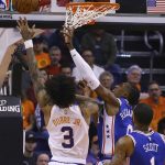Phoenix Suns forward Kelly Oubre Jr. (3) shoots over Philadelphia 76ers forward Mike Scott (1) and guard Josh Richardson, center, during the first half of an NBA basketball game Monday, Nov. 4, 2019, in Phoenix. (AP Photo/Ross D. Franklin)