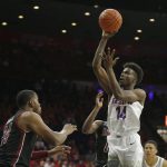 Arizona guard Devonaire Doutrive (14) shoots over New Mexico State forward William McNair in the second half of an NCAA college basketball game, Sunday, Nov. 17, 2019, in Tucson, Ariz. (AP Photo/Rick Scuteri)