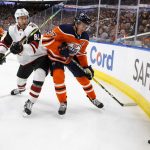 Arizona Coyotes ' Jordan Oesterle (82) and Edmonton Oilers' Connor McDavid (97) battle for the puck during second-period NHL hockey game action in Edmonton, Alberta, Monday, Nov. 4, 2019. (Jason Franson/The Canadian Press via AP)