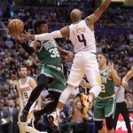Boston Celtics guard Marcus Smart (36) passes around Phoenix Suns guard Jevon Carter (4) during the first half of an NBA basketball game, Monday, Nov. 18, 2019, in Phoenix. (AP Photo/Matt York)