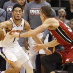 Phoenix Suns' Devin Booker (1) steals the ball from Miami Heat's Duncan Robinson (55) during the second half of an NBA basketball game Thursday, Nov. 7, 2019, in Phoenix. (AP Photo/Darryl Webb)